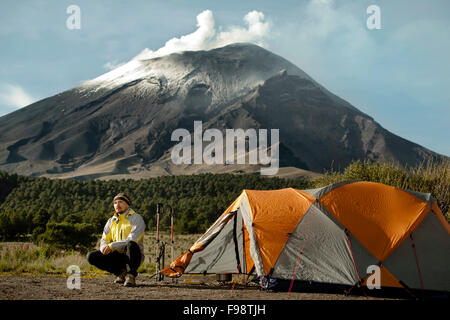 Un uomo e la sua tenda a Paso il Cortez, con vulcano Popocatepetl nel retro. Foto Stock