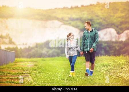 Coppia giovane in colorate wellies passeggiate nella natura fangosi. Foto Stock