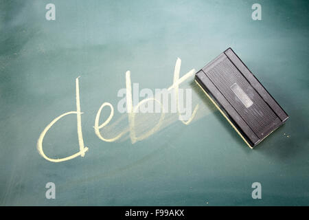 Il debito di parola scritta in gesso su una lavagna sfregata fuori da una gomma Foto Stock