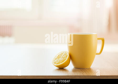 Tazza di tè e caffè e limone closeup con sunny interno di una casa in background Foto Stock