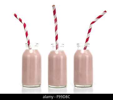 Tre bottiglie di latte rosa rossa e bianca a strisce cannucce su sfondo bianco Foto Stock