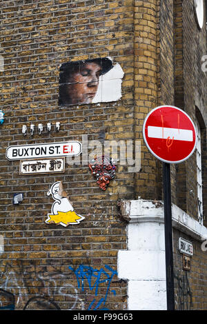 Arte di strada su un muro di mattoni in Buxton Street, Shoreditch, nel quartiere di Tower Hamlets Foto Stock