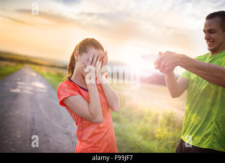 Cross-country trail running giovane avente acqua break al tramonto Foto Stock