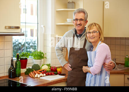 Felice coppia di anziani in piedi sorridente in una cucina nuova Foto Stock