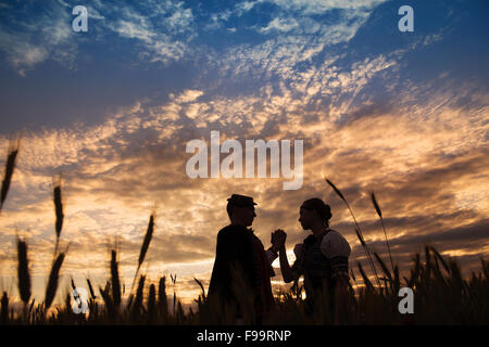 Amore matura in campo al tramonto. Essi indossando il tradizionale orientale costumi folcloristici. Foto Stock