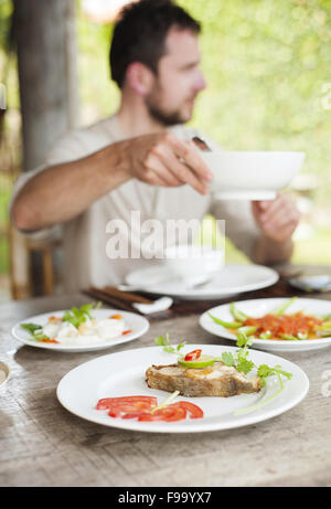 L'uomo gustando un pasto con bacchette in ristorante vietnamita Foto Stock