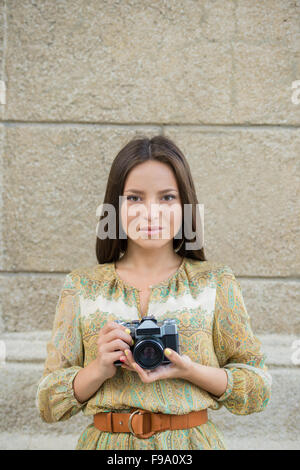 Hipster donna scattare foto con retro telecamera cinematografica Foto Stock