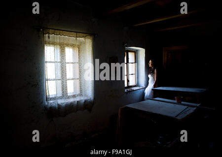 Bella e felice bruna sposa in posa nella vecchia casa Foto Stock