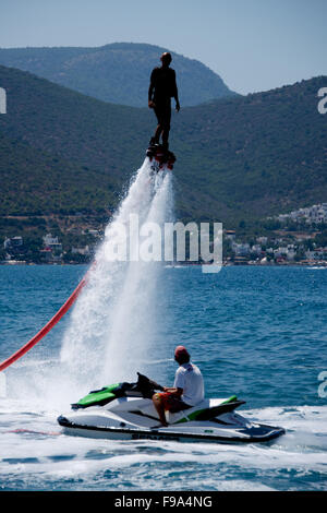 Flyboarder in nero al di sopra di un uomo su jetski Foto Stock