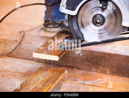 Grinder Elettrico macchina a sinistra su polverosi pavimenti in legno con trucioli di legno Foto Stock