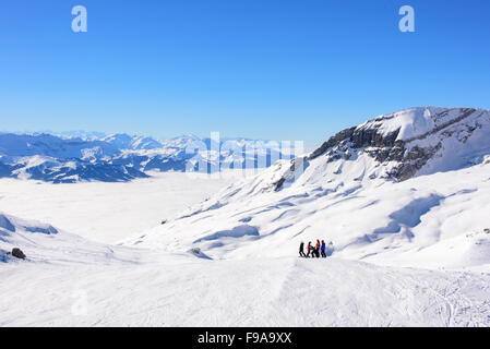 Francese e alpi svizzere sopra le nuvole. Un gruppo di sciatori hanno smesso di prendere in vista. Neve montagna alpina ridge in b Foto Stock