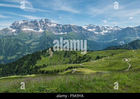 Estate in vista delle Alpi svizzere presa da sopra Champery verso Les Dents du Midi. Campi verdi, strade tortuose e foresta. Foto Stock