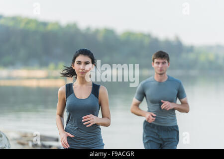 Allegro caucasico ispanica giovane in esecuzione sulla spiaggia di mattina Foto Stock