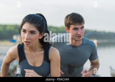 Allegro caucasico ispanica giovane in esecuzione sulla spiaggia di mattina Foto Stock