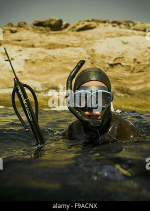 Una lancia di fisher galleggia in acqua con il suo fucile. Foto Stock