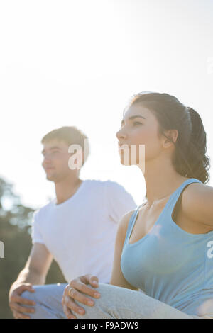 Coppia giovane facendo stretching esercizi yoga con il mare sullo sfondo Foto Stock