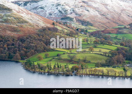 Un panorama verso il basso in Ullswater e terreni agricoli circostanti nel Lake District Cumbria Regno Unito in inverno con Snow capped mountai Foto Stock