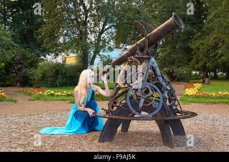 Bella ragazza guarda attraverso il telescopio nel parco Foto Stock