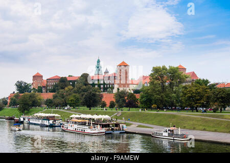 Vista del castello di Wawel con ristoranti barche ormeggiate sul fiume Wista in Riverside park. Cracovia in Polonia, Europa Foto Stock