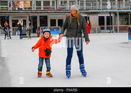 Glasgow, Scotland, Regno Unito. 15 Dic, 2015. Glasgow annuali di 'Natale sul ghiaccio' outdoor spettacolare pista di pattinaggio su ghiaccio in George Square nel centro della città attrae i pattinatori di tutte le età e abilità. Coloro che sono un po' incostante sul ghiaccio ottieni un qualche aiuto da parte di genitori e parenti. Un modo divertente per avere una pausa da shopping di Natale.Qui Adam Fyfe, di età compresa tra i 4, da Kirkintilloch è il pattinaggio con la madre, Angela. Credito: Findlay/Alamy Live News Foto Stock