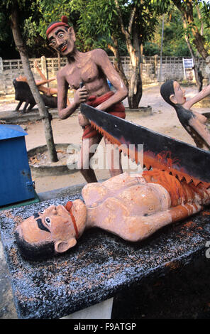 Sculture concrete di punizione e tortura di peccatore maschio o criminale, essendo Sawn in mezzo, per rubare, riscaldare o distruggere la proprietà. Scultura d'arte popolare di kitsch nel Giardino dell'Inferno di Wat Wang Saen Suk nei terreni del Tempio, Bang Saen, Chonburi Thailandia Foto Stock