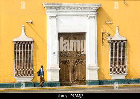 Uomo che cammina passato edificio in stile coloniale nella piazza principale della città di Trujillo nel nord del Perù Foto Stock