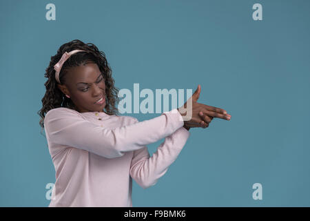 Donna africana compiendo il gesto di pistola dalle sue mani e tiro Foto Stock