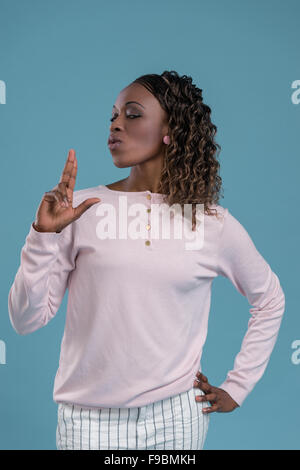 Donna africana compiendo il gesto di pistola dalle sue mani e tiro Foto Stock