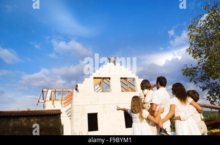 Felice e grande famiglia costruisce una nuova casa per la vita Foto Stock