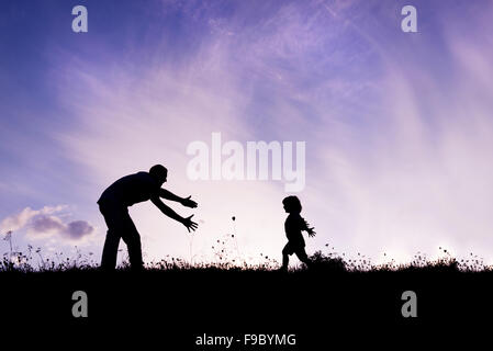 Silhouette di padre felice avendo divertimento con suo figlio Foto Stock