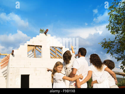 Felice e grande famiglia costruisce una nuova casa per la vita Foto Stock