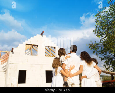 Felice e grande famiglia costruisce una nuova casa per la vita Foto Stock