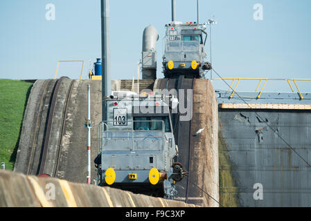 Serrande di Miraflores Canale di Panama Panama | CANALE DI PANAMA, Panama — Locomotive di rimorchio accoppiate superano le pareti delle serrande alle Serrande di Miraflores, parte del sistema delle mule che trascina le navi attraverso le camere sul lato pacifico del Canale di Panama. Datate all'apertura del canale nel 1914, queste unità montate su rotaie guidano ancora le navi attraverso le serrande originali della via d'acqua lunga circa 50 miglia (80 km), che solleva le navi di circa 85 piedi (26 m) oltre la linea di divisione continentale. Foto Stock