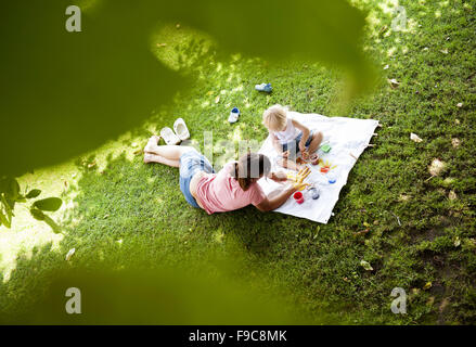 Carino bambino dipinto con colori vivaci in giardino Foto Stock