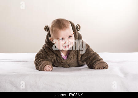 Sweet Little baby è sdraiato sul materasso in studio Foto Stock