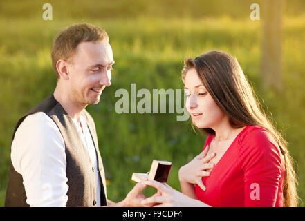 Giovane uomo chiede bella ragazza per la mano Foto Stock