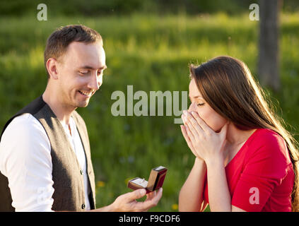 Giovane uomo chiede bella ragazza per la mano Foto Stock