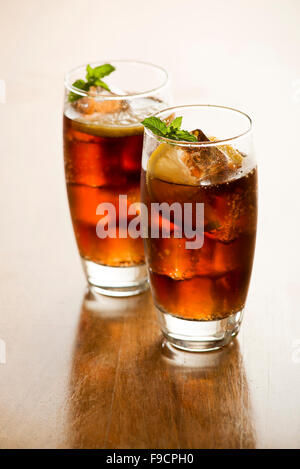 Due bicchieri di Coca Cola fresca o soda drink con cubetti di ghiaccio e limone. Foto Stock