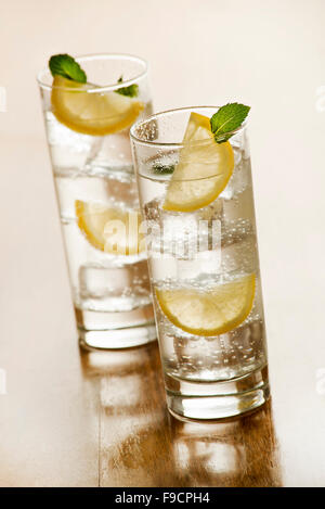 Due bicchieri di fresca acqua minerale con ghiaccio e limone. Foto Stock