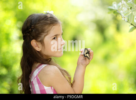 Bambina sta giocando con farfalla in natura Foto Stock