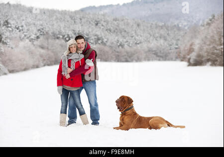 Donna e uomo sono avente la passeggiata con il cane in inverno paesaggio innevato Foto Stock