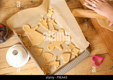 Preparazioni di natale. La realizzazione di pan di zenzero è un tempo onorata tradizione. Il pan di zenzero viene tagliato dalla pasta laminata. Foto Stock