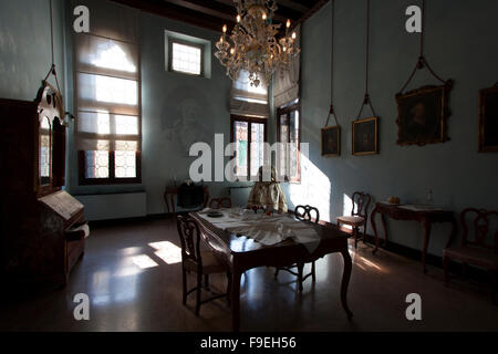 La tabella di cui fuori a cena in una stanza con un sacco di windows Foto Stock