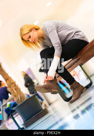 Bella donna con braccio rotto all'interno di un centro commerciale Foto Stock