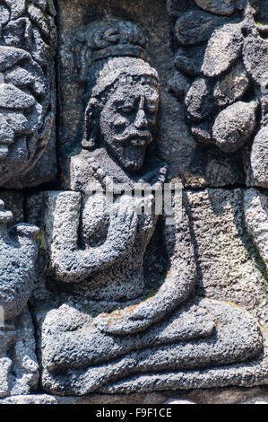 Meditando e seduta stone carving a Borobudur Foto Stock