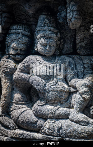 Medidating e seduta stone carving a Borobudur Foto Stock