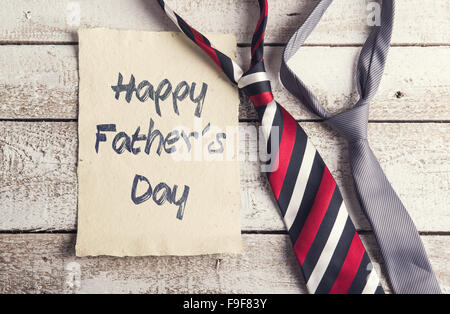 I padri felice giorno segno sulla carta e fascette colorate prevista sul pavimento in legno backround. Foto Stock