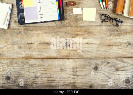 Mix di forniture per ufficio su una tavola di legno dello sfondo. Vista da sopra. Foto Stock