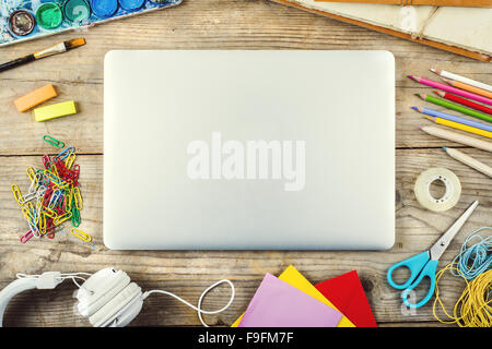 Escursioni di un artista con un sacco di oggetti di cancelleria. Studio shot su sfondo di legno. Foto Stock