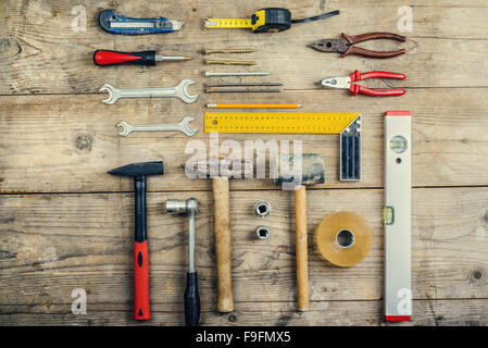 Desk di un falegname con strumenti diversi. Studio shot su uno sfondo di legno. Foto Stock